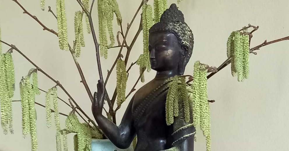 Buddha in springtime at The Barn retreat centre at The Sharpham Trust